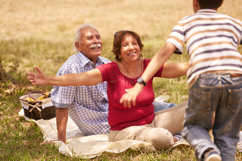 Son running to grandparents having a picnic