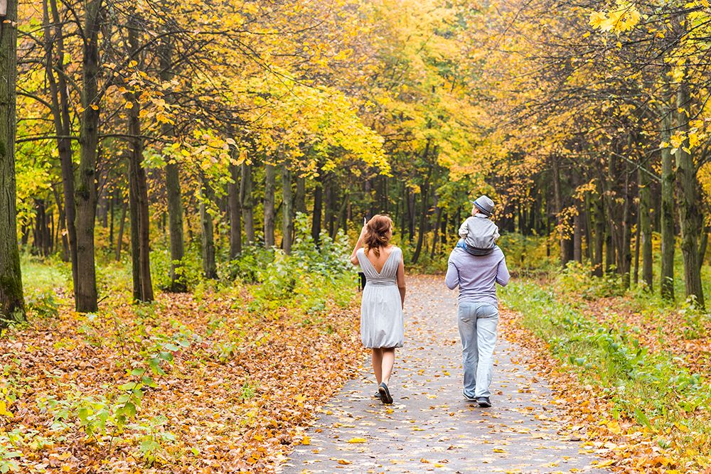 Couple walking with baby on Dad's shoulders